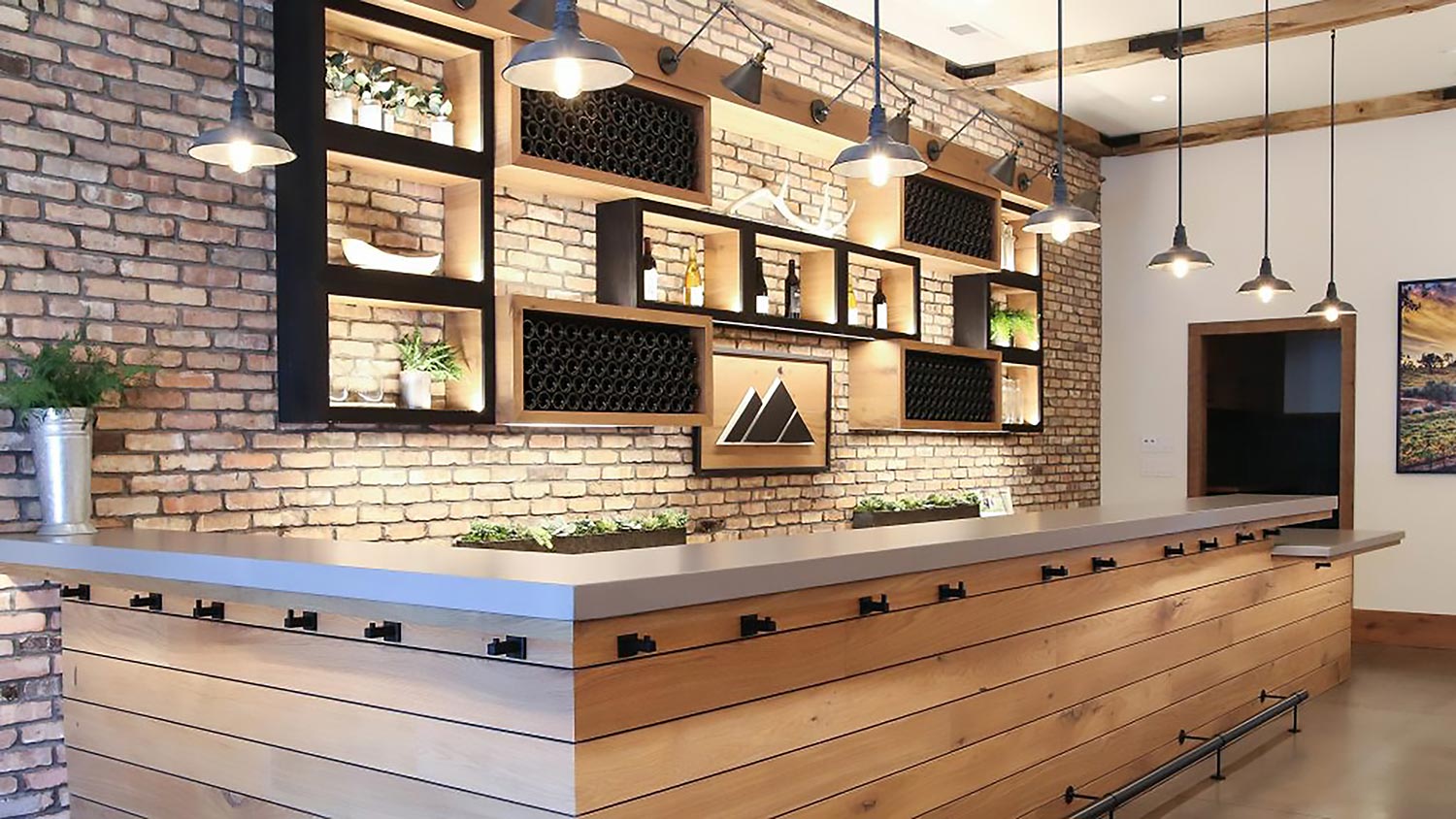 Stylish bar area with exposed brick walls, custom shelving, and pendant lighting creating a warm ambiance.